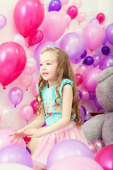 Fototapeta na wymiar Image of cute little girl playing among balloons