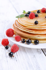 Sweet pancakes with berries on table close-up