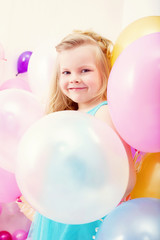 Fototapeta na wymiar Funny little girl posing with balloons