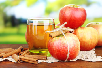 Ripe apples with with cinnamon sticks and glass of  apple drink