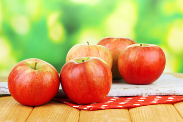 Ripe apples on  wooden table, on bright background