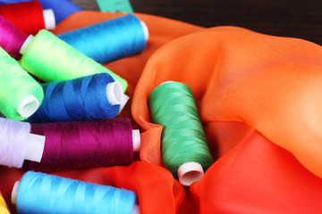 Multicolor sewing threads on color fabric background