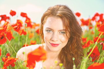 Naklejka premium Beautiful young woman in poppy field
