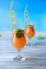 Grapefruit cocktail with cocktail straw on bright background