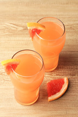Grapefruit cocktail in glasses on wooden background