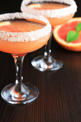 Grapefruit cocktail in glasses on wooden background