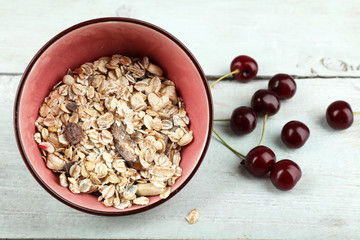 Homemade granola in bowl on color wooden background