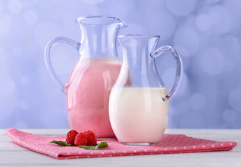 Glass jug of milk cocktail with raspberry taste
