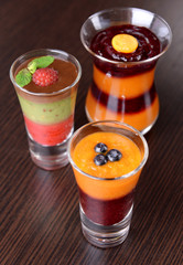 Glasses of tasty fruit and berry smoothies on wooden background