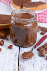 Sweet chocolate cream in jar on table close-up