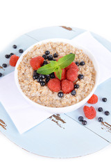 Tasty oatmeal with berries isolated on white