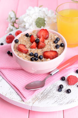 Tasty oatmeal with berries on table close-up