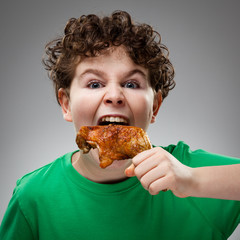 Boy eating roasted chicken leg