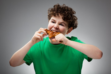 Boy eating roasted chicken leg