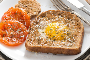 fried egg and tomatoes in a toast for breakfast, close-up