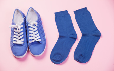 Gumshoes and socks in pink background.