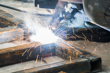 Worker welding steel with sparks lighting