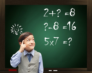 Little boy Thinking mathematics on blackboard in the background