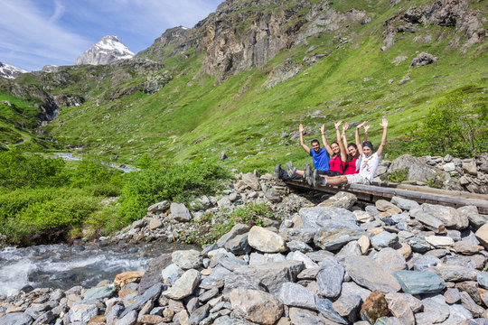 Ragazzi in montagna seduti su ponte