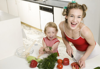 Happy housewife with daughter at the kitchen