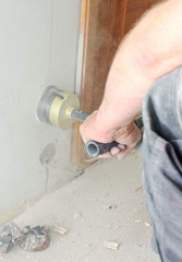 Man with Hammer drill doing hole for socket.