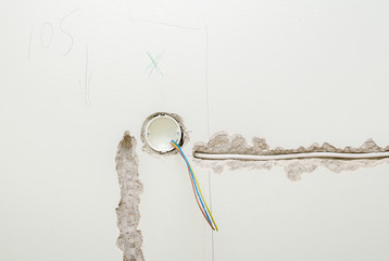 Undone AC power socket in wall. Repairs in the apartment.