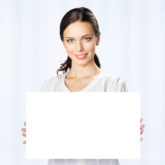 Businesswoman showing blank signboard, at office