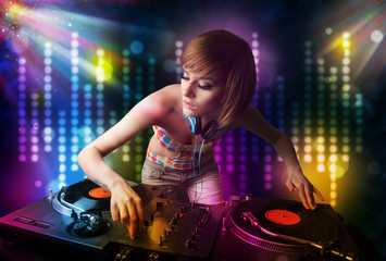 Obraz na płótnie Canvas Dj girl playing songs in a disco with light show