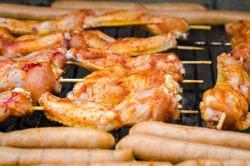 Sausages and chicken wings on smoking grill barbeque