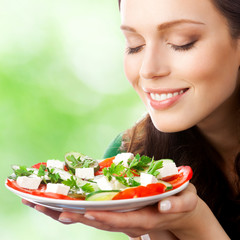 Portrait of happy smiling woman with plate of salad