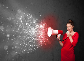 Woman shouting into megaphone and glowing energy particles explo