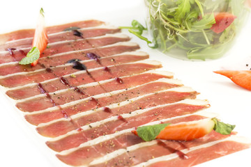sliced goose meat and a salad of arugula