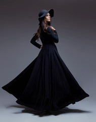 Elegant woman in a hat and long fluttering dress