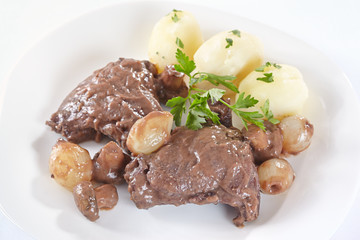 Chicken in red wine with onions, mushrooms and bacon