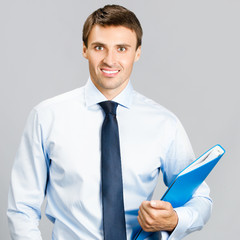 Business man with folder, on gray