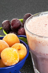 Cherry and plum in a colander and a milkshake
