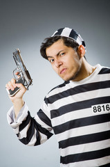 Prisoner with gun against dark background