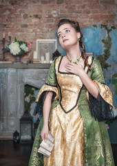 Sad woman in medieval dress holding letter