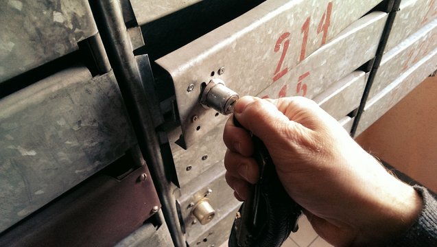 Male Hand With Key Opening An Old Metal Post Box