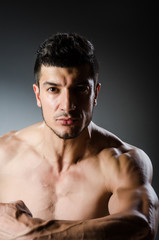 Fototapeta premium Muscular man posing in dark studio
