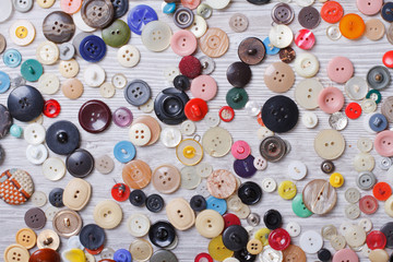 Background of old buttons on wooden board closeup