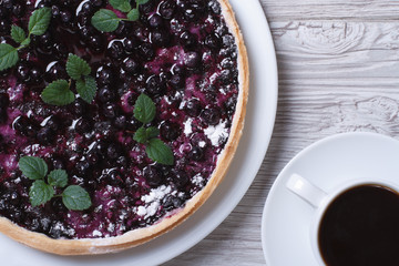 blueberry pie with mint and black coffee on a wooden background