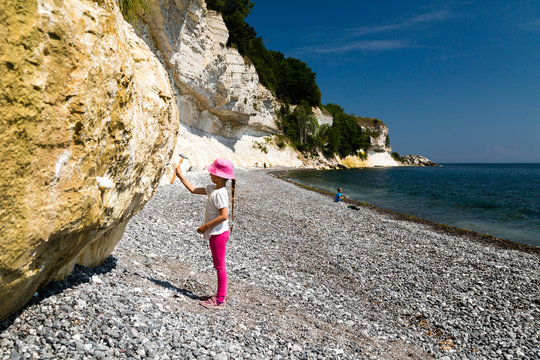 Girl chopping at chalk cliffs
