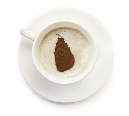 Obraz premium Cup of coffee with foam and powder in the shape of Sri Lanka.(se