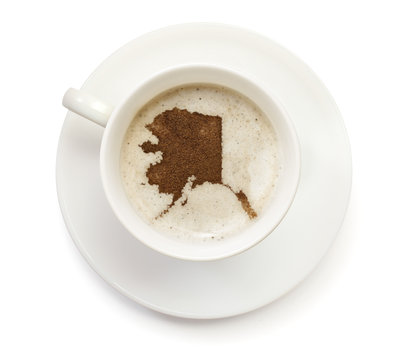 Cup of coffee with foam and powder in the shape of Alaska.(serie