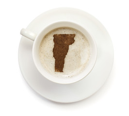 Cup of coffee with foam and powder in the shape of Vermont.(seri