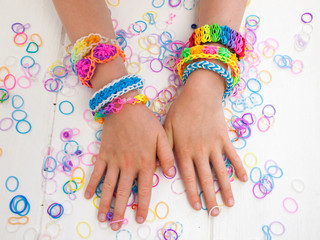arms of a child wearing multicoloured bracelets