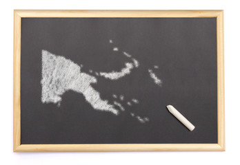 Blackboard with a chalk and the shape of Papa New Guinea drawn o
