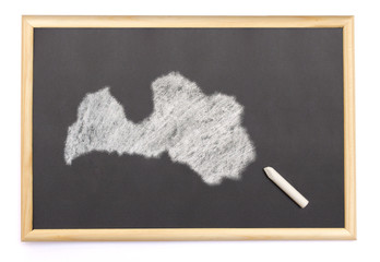 Blackboard with a chalk and the shape of Latvia drawn onto. (ser