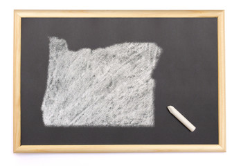 Blackboard with a chalk and the shape of Oregon drawn onto. (ser